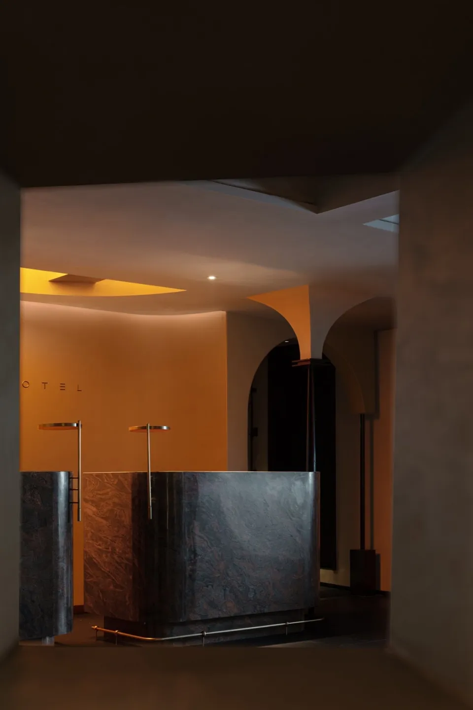 A modern reception desk made of marble in a hotel lobby.