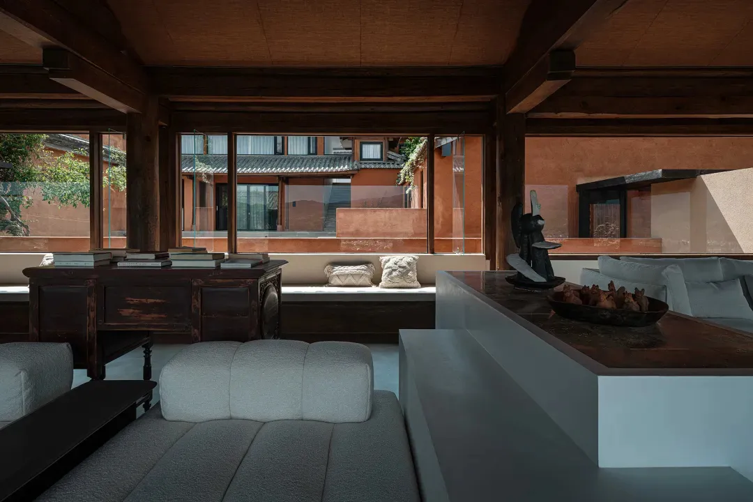 Modern living room with wooden furniture, large windows, and a comfortable seating area.