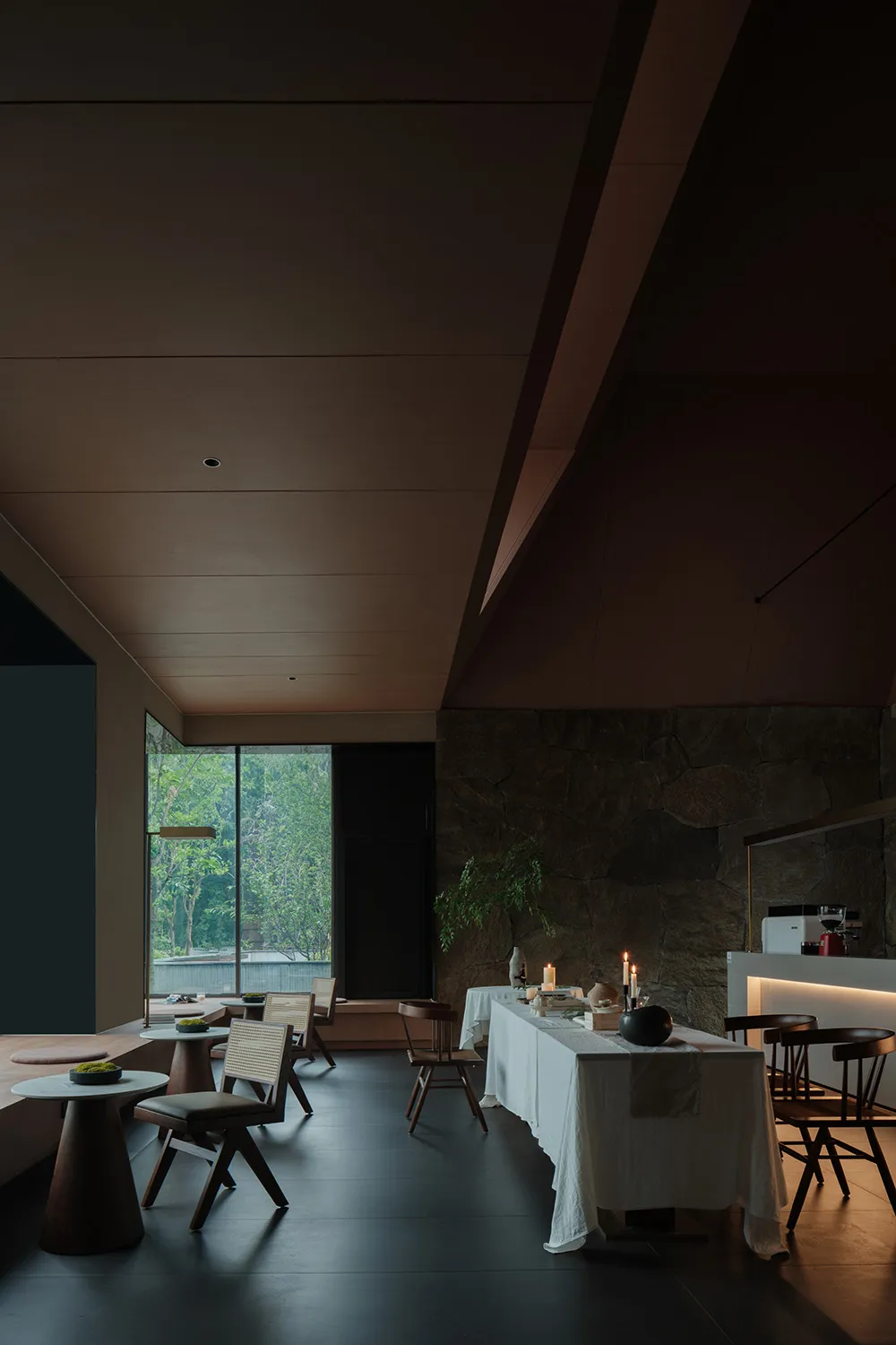 現代餐廳用餐區，石材地板、俐落家具與自然光線。