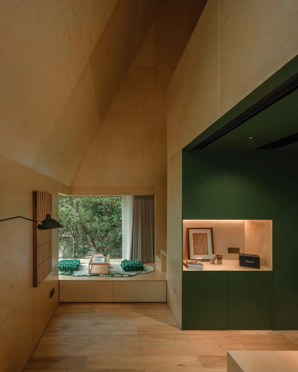Modern cozy lounge with wooden walls, high ceiling, and green accents.
