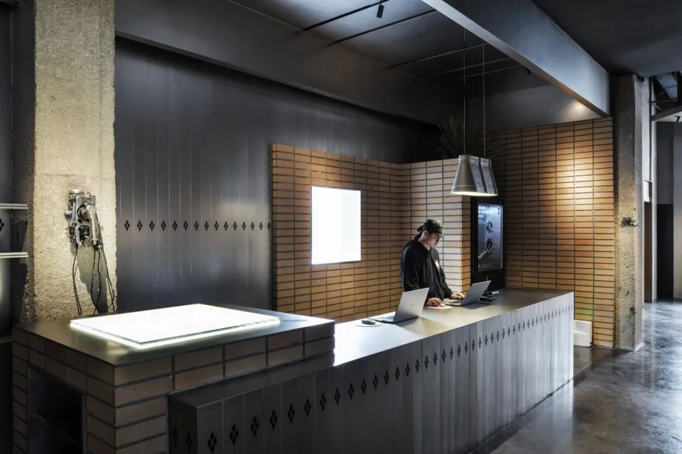 A modern office with a concrete and brick wall, and a metal counter.