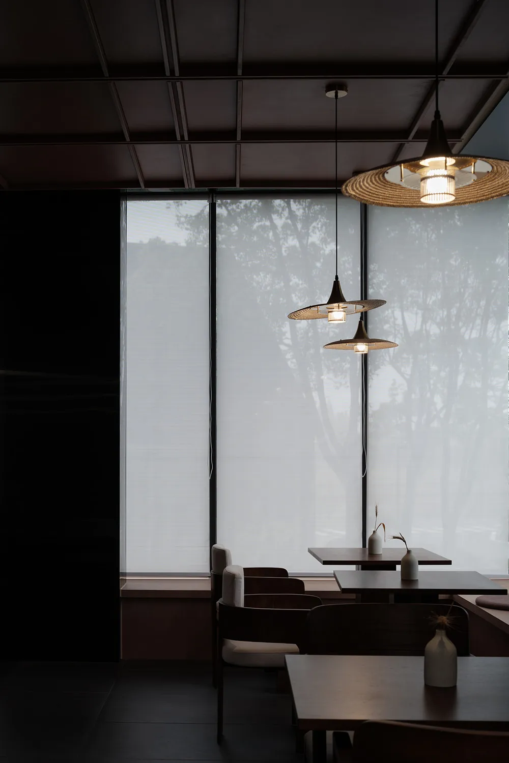 A modern restaurant interior featuring glass walls and minimalistic design elements.