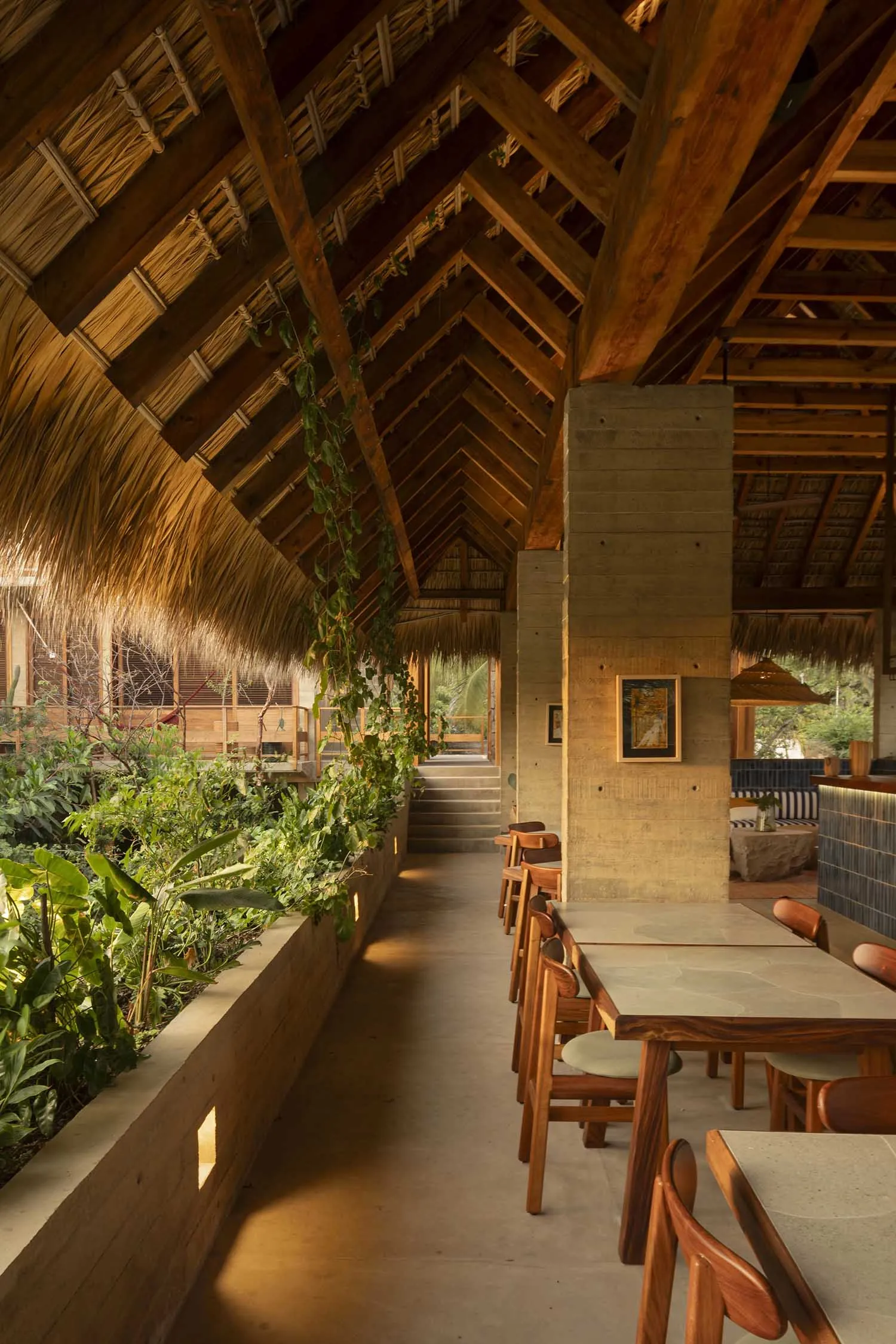 Interior design of a restaurant featuring a mix of wooden and concrete materials.