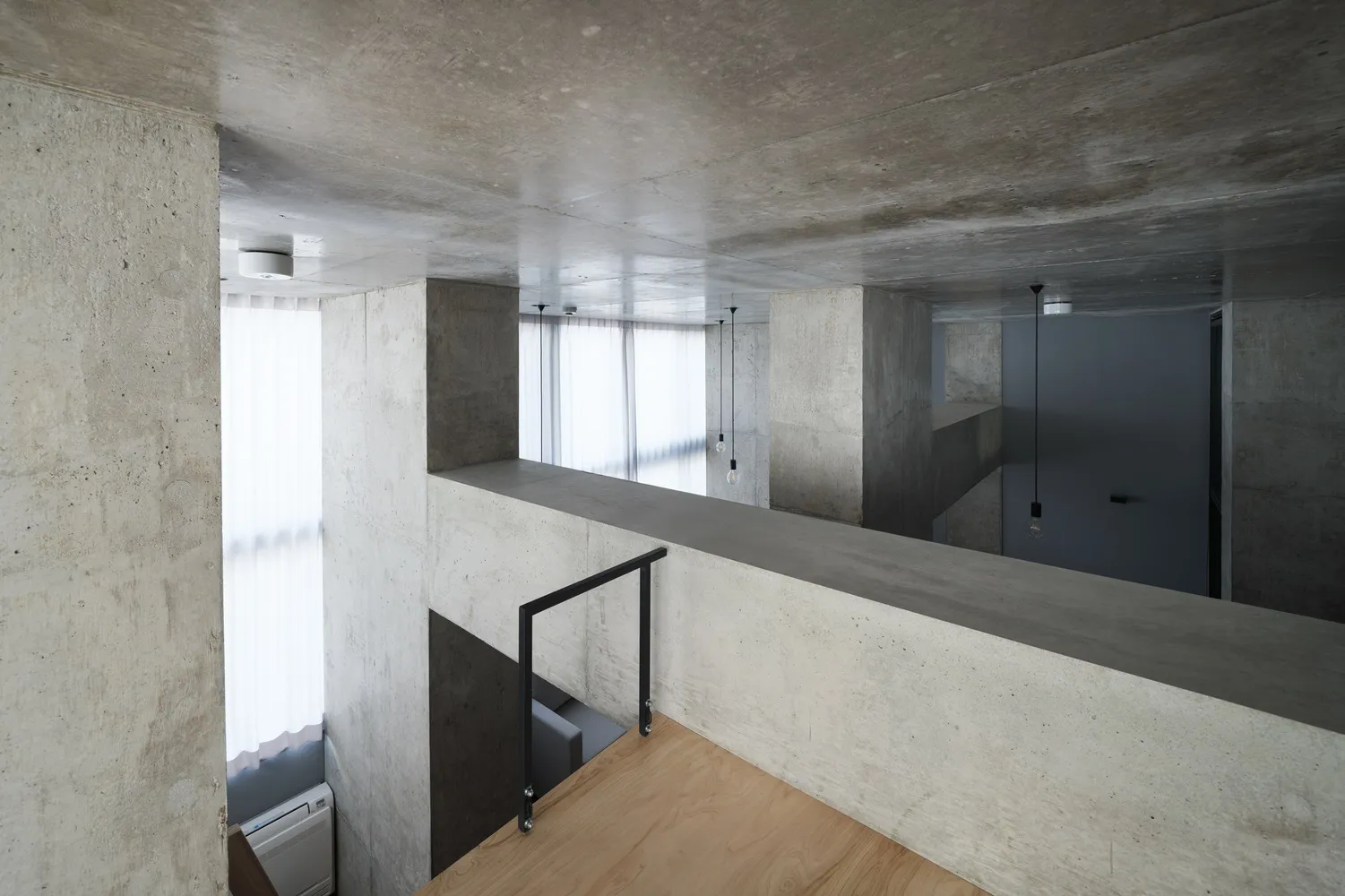 A modern building interior with concrete walls and wooden floors.