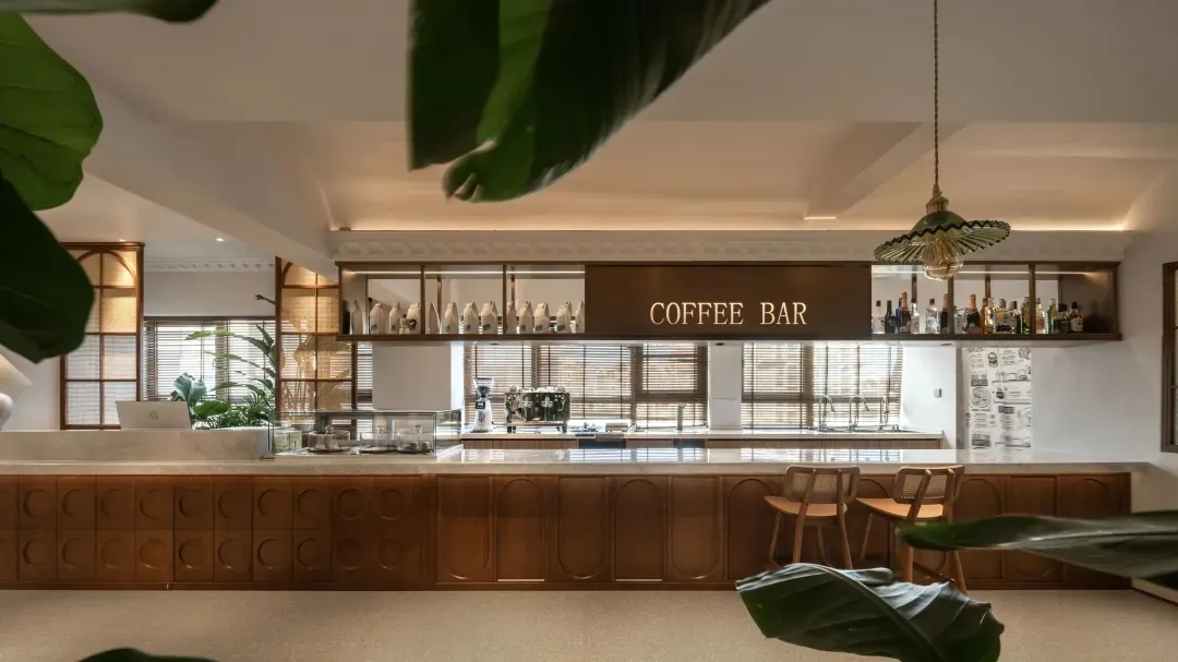 A minimalist coffee bar featuring wooden cabinets and marble countertops.