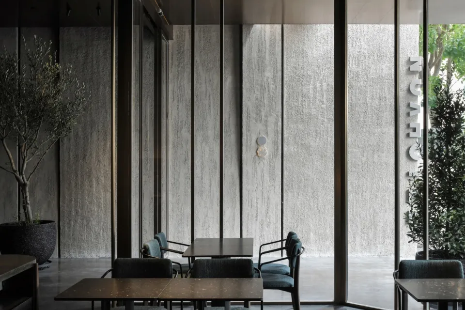 Concrete restaurant interior with industrial design elements, featuring industrial-style tables and chairs.