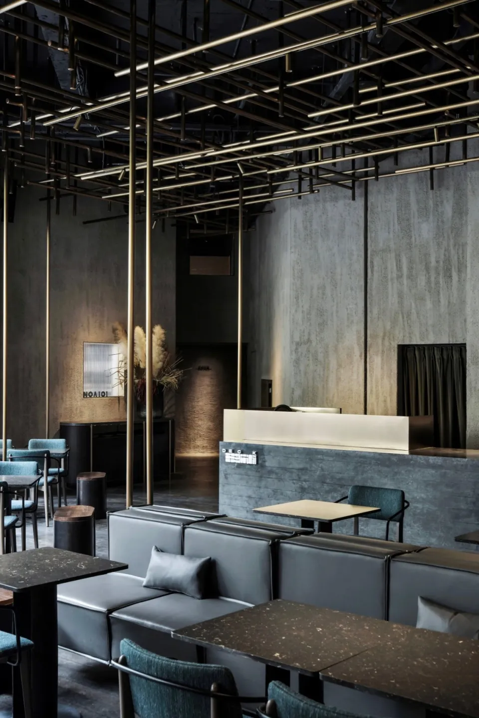 Industrial-style bar area with concrete walls, metal lighting fixtures, and leather seating.