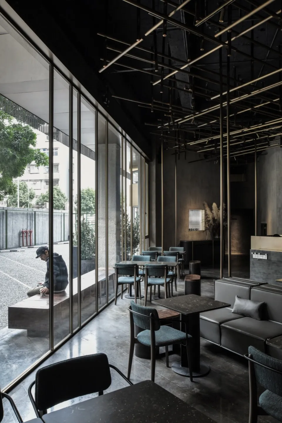 現代工業風餐廳室內,採用金屬與混凝土元素,並搭配大型窗戶。