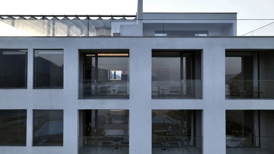 A modern minimalist building with glass terraces