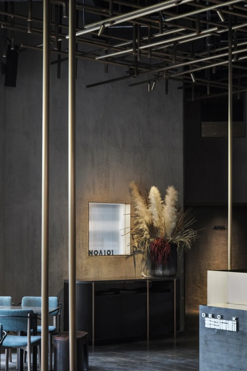Concrete walls, industrial lighting, and minimalist decor of a restaurant interior