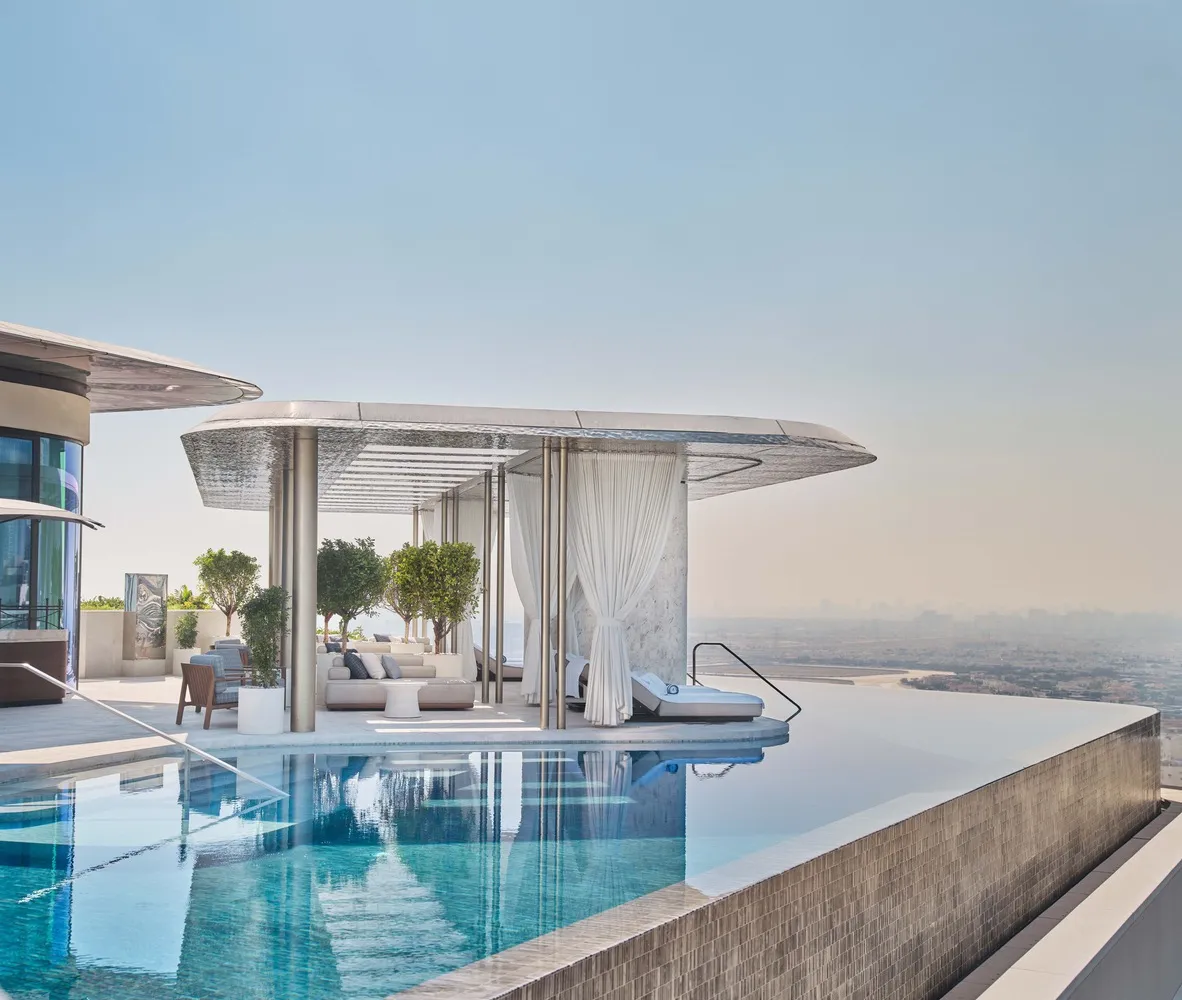 Modern, minimalist rooftop pool deck featuring glass walls and a sleek, contemporary design.