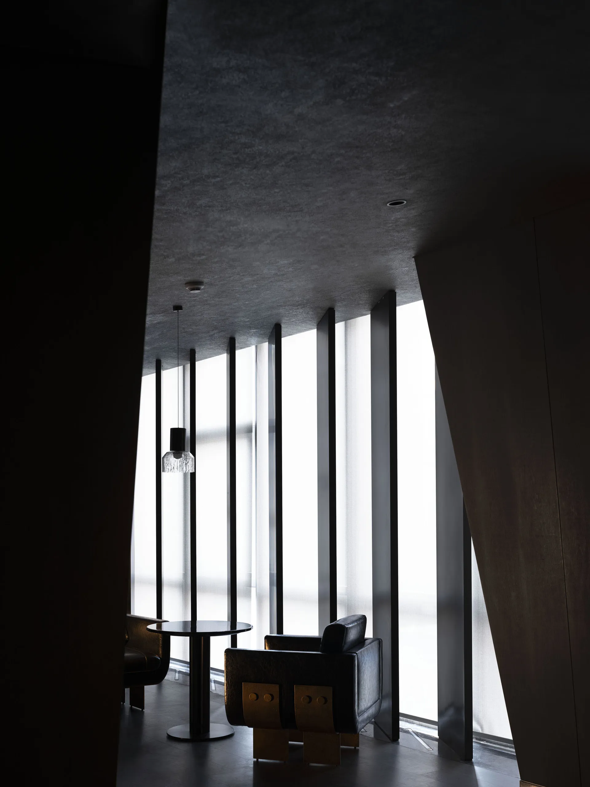 A modern lobby space featuring glass and concrete materials.