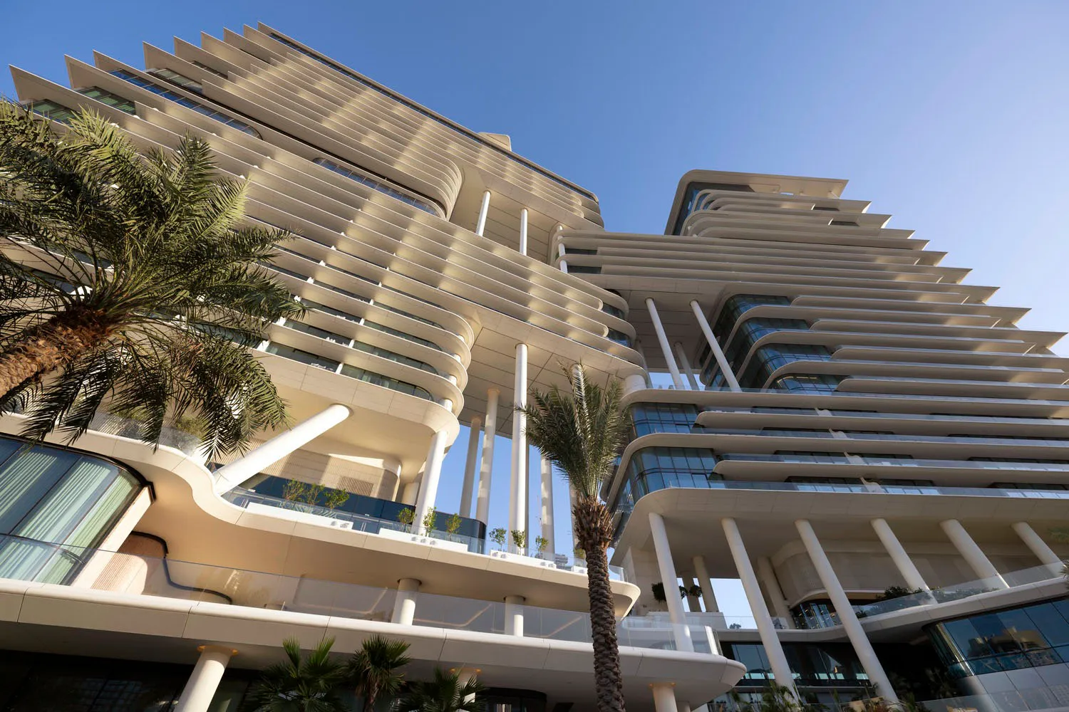 Modern residential building with concrete facade, glass windows, and steel beams.