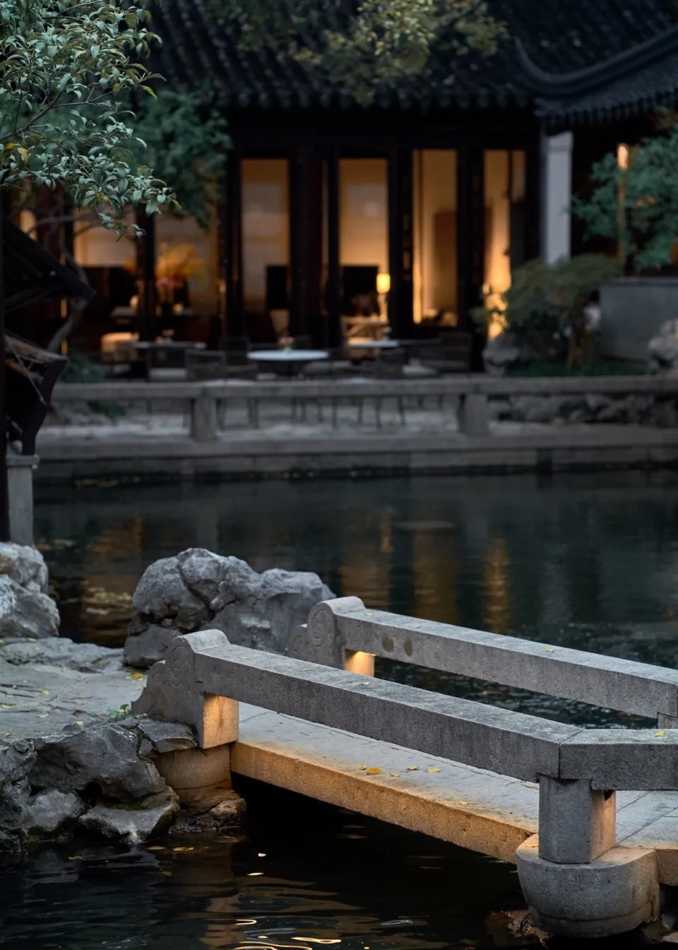 寧靜的花園景觀,石橋橫跨水面,背景為傳統中式建築。