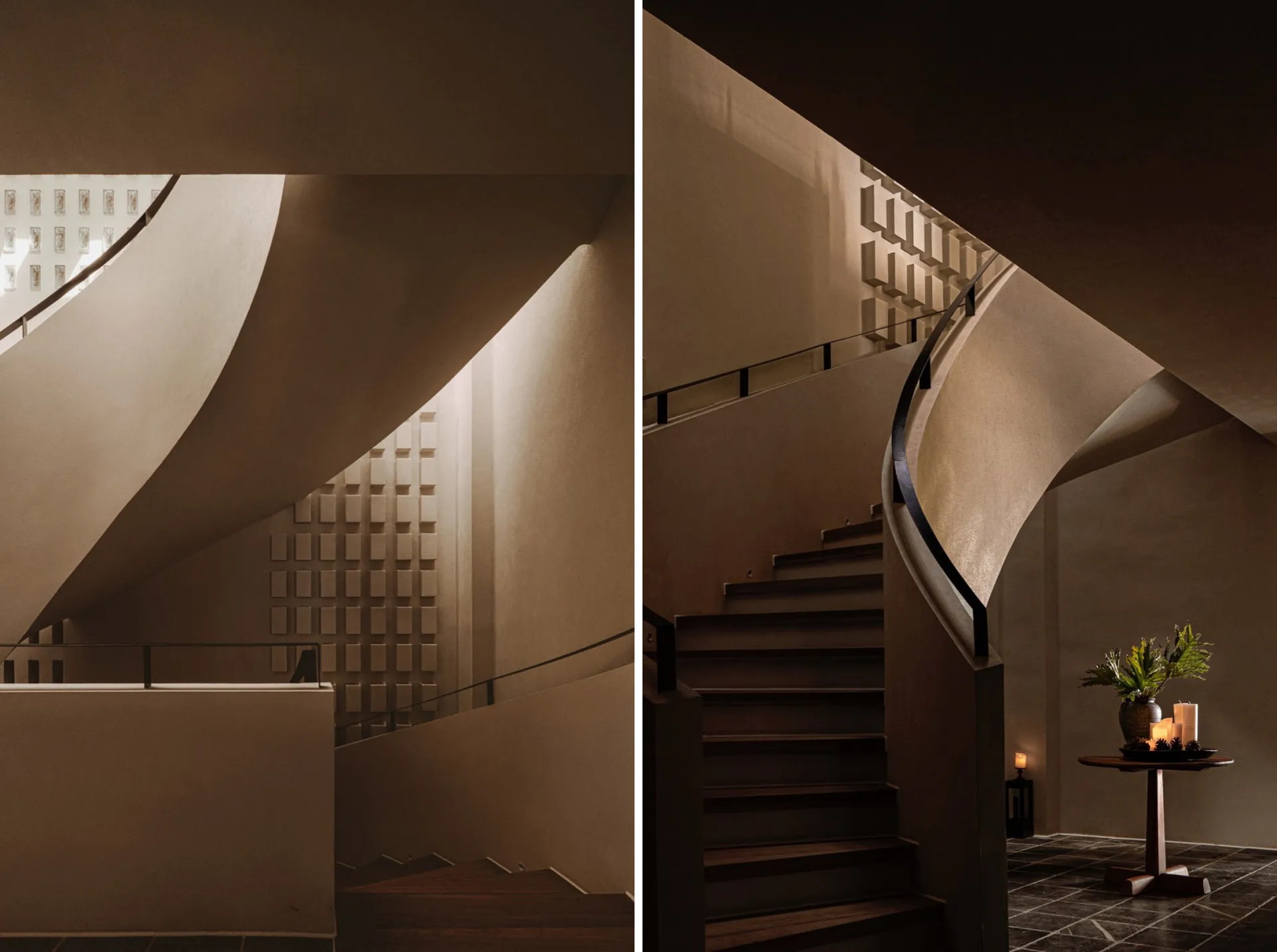 Modern interior staircase featuring a concrete wall and black handrail.