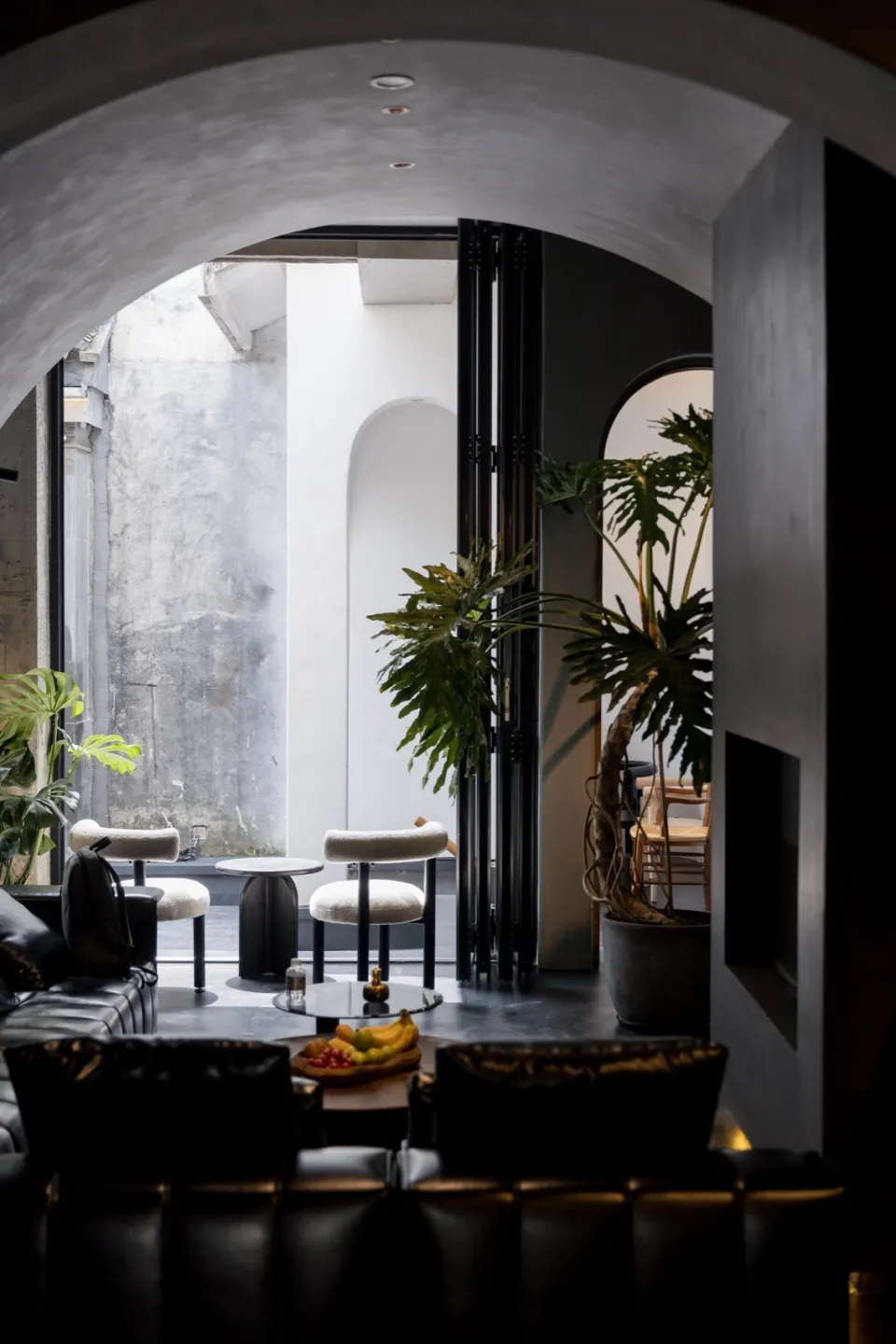 A modern restaurant lounge with concrete, leather, and glass materials.