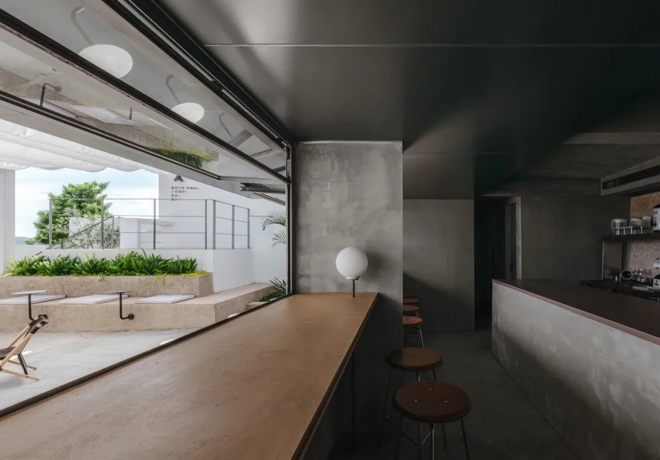 Modern interior design featuring a concrete and wood bar counter with minimalistic aesthetics.
