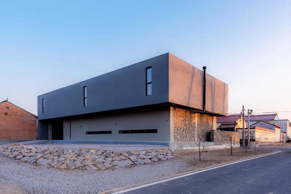 A sleek, modern building exterior in concrete and metal with a unique design