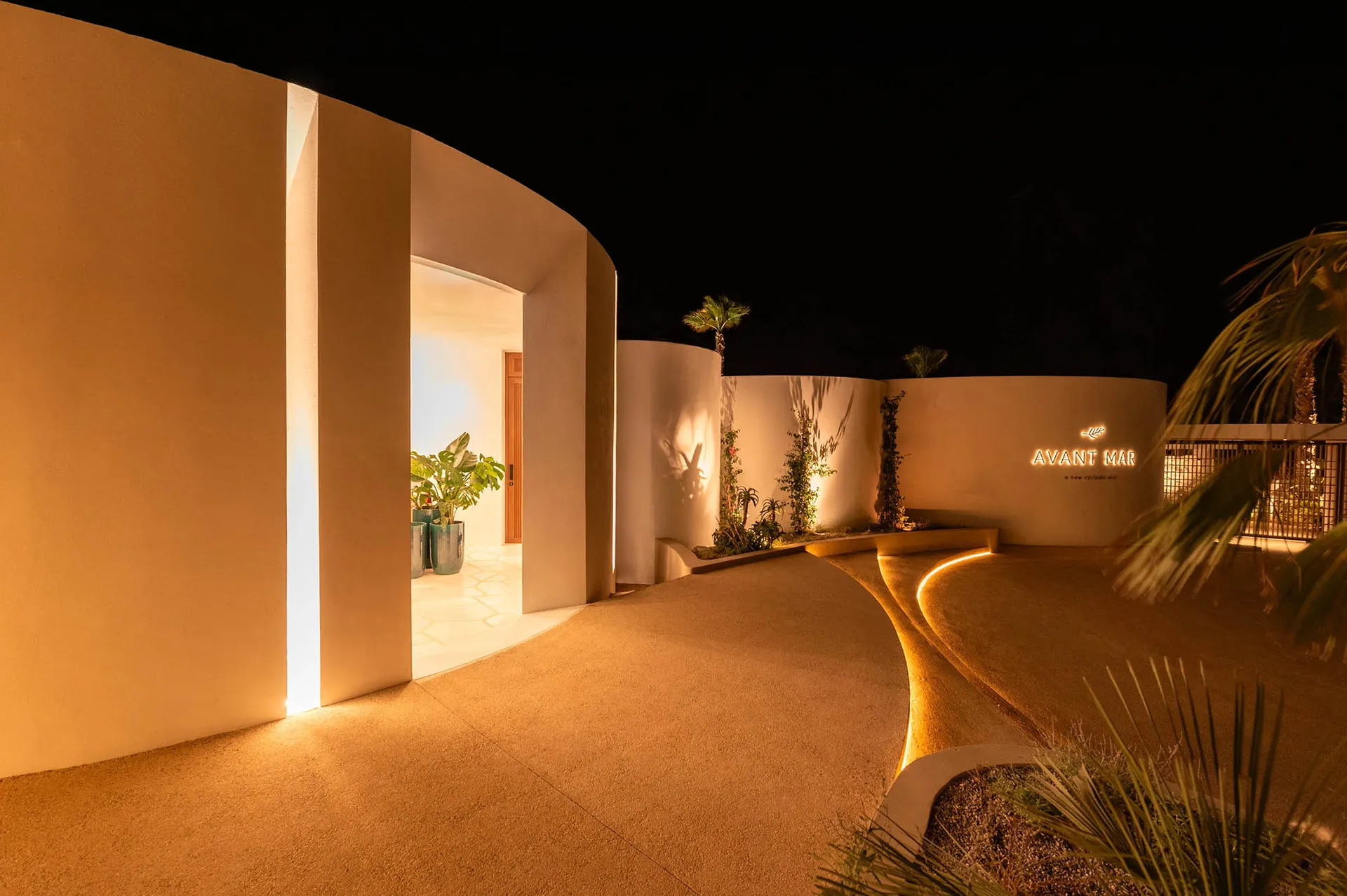 Concrete entrance pathway with warm lighting and minimalist design.