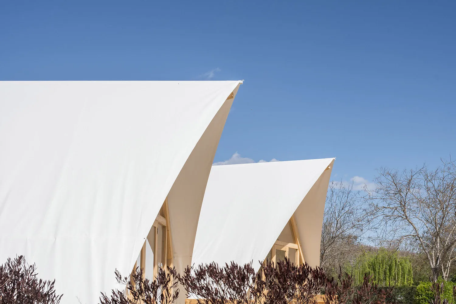 Modern building with a white fabric exterior under a clear blue sky.