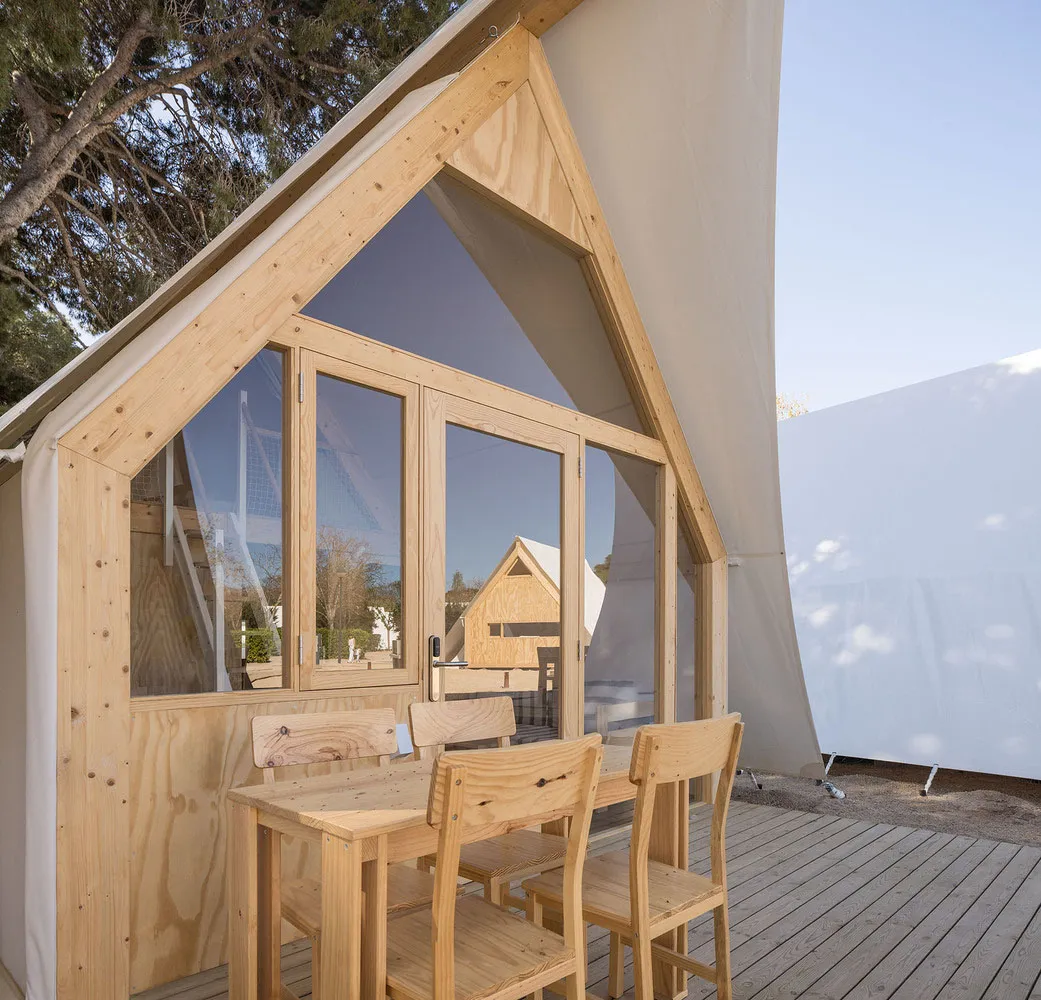 A modern outdoor relaxation space featuring wood and tampered canvas exterior materials.