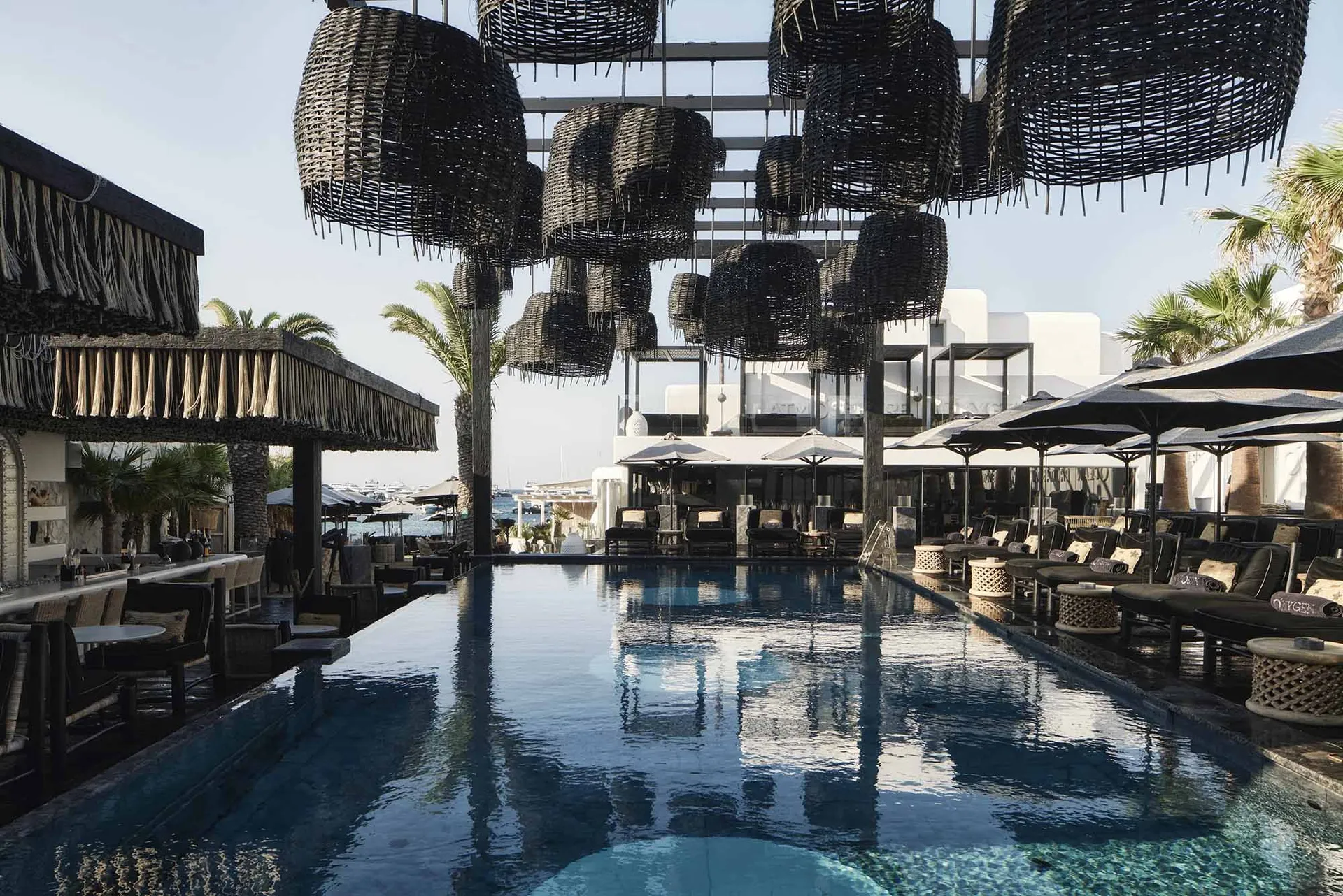 Modern poolside area featuring wicker designs.