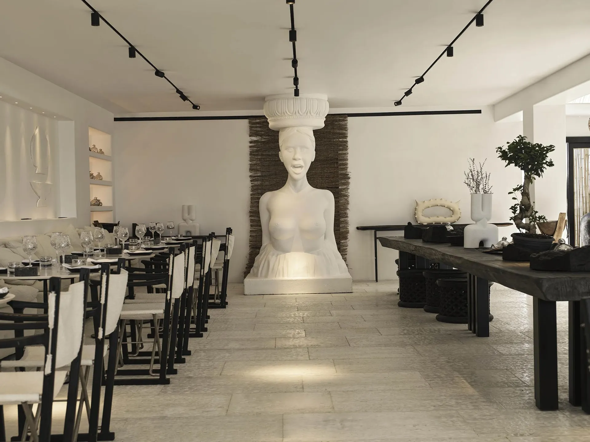 Modern restaurant interior featuring concrete flooring and mixed materials decor.