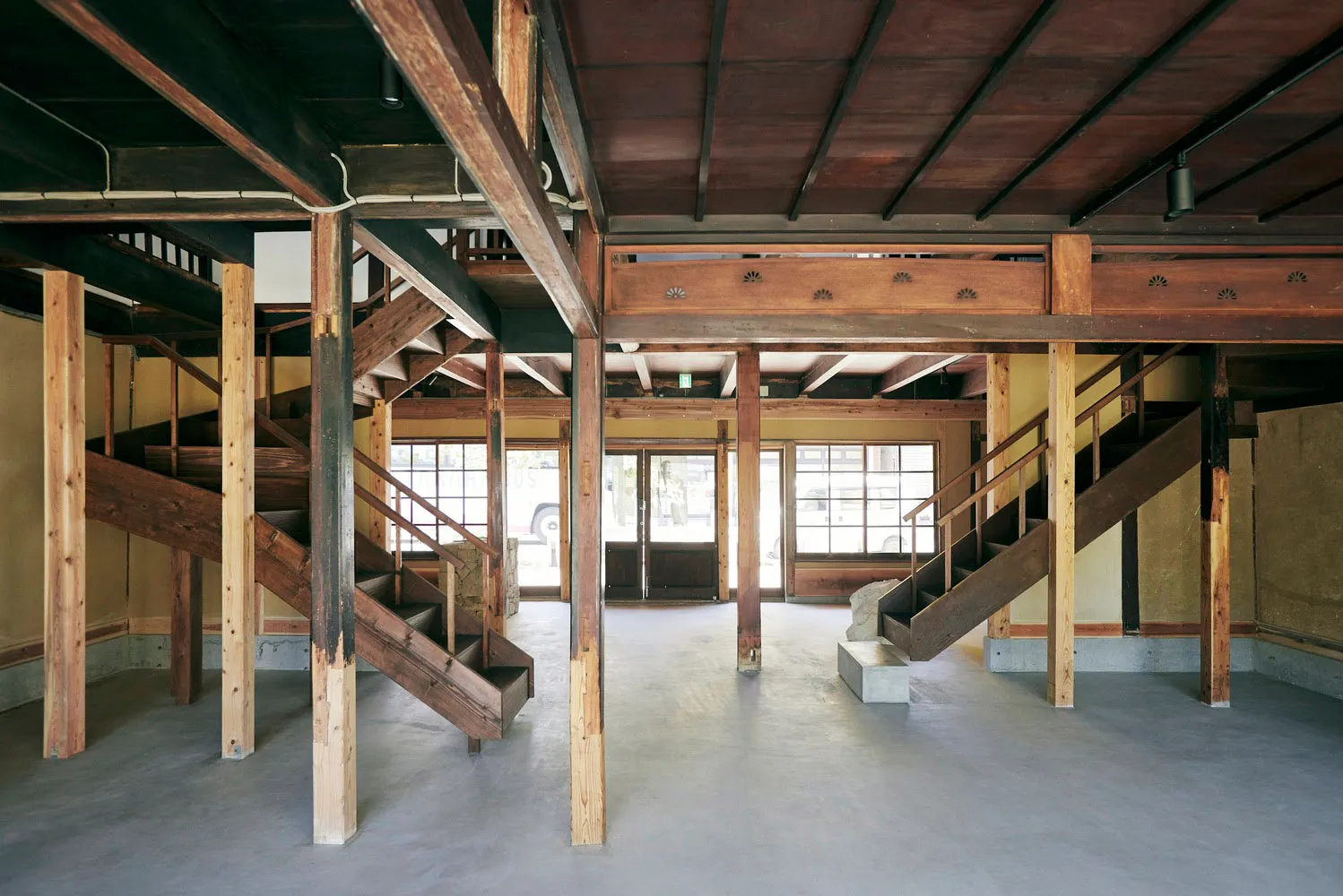 A spacious commercial interior with wooden structural elements and a concrete floor.
