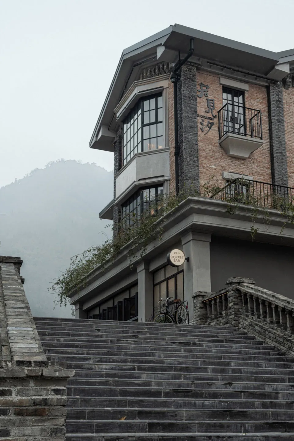 A stone staircase leading up to a brick building exterior with a glass coffee bar sign.