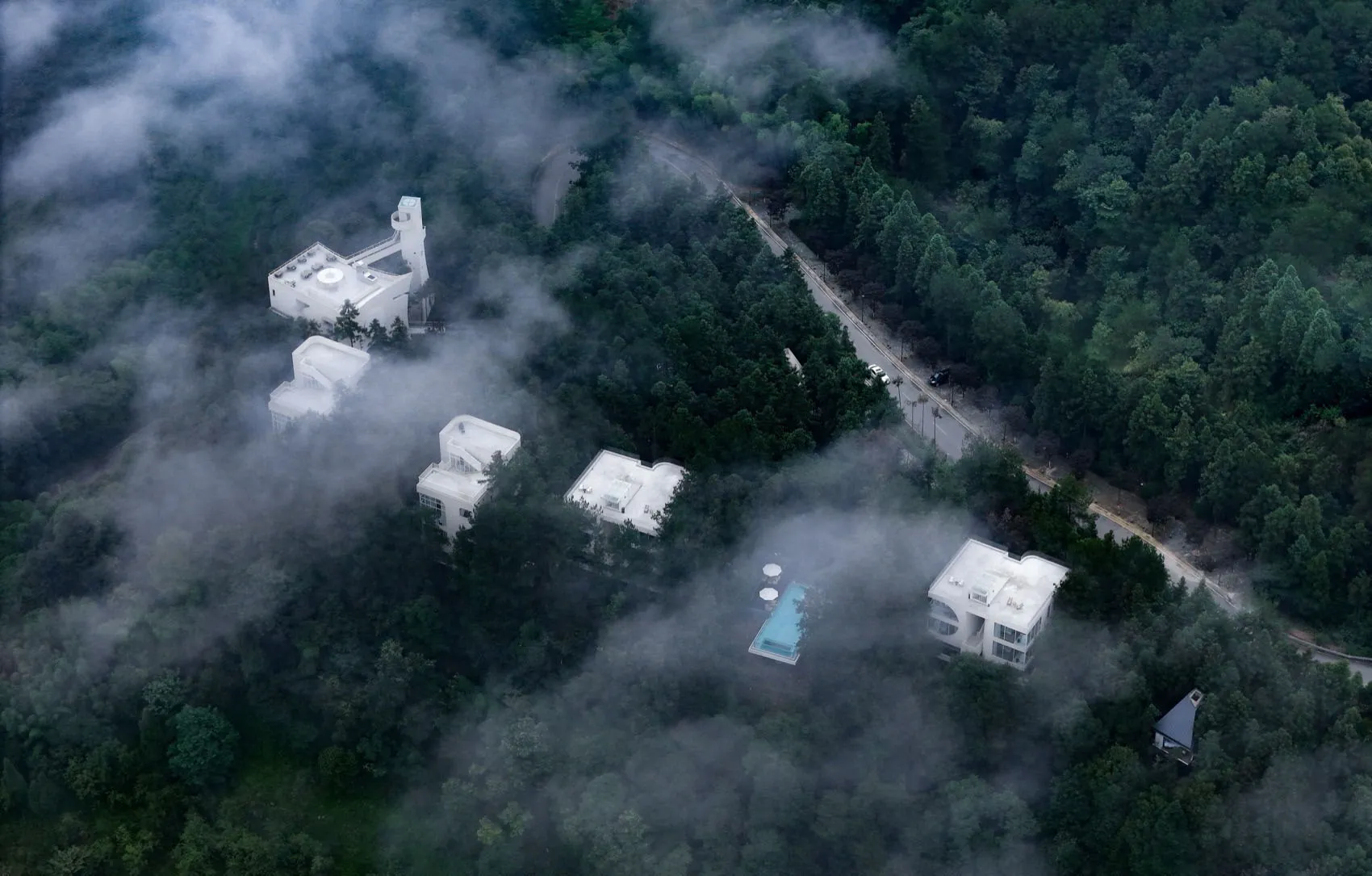Modern residential buildings surrounded by clouds with concrete and glass materials
