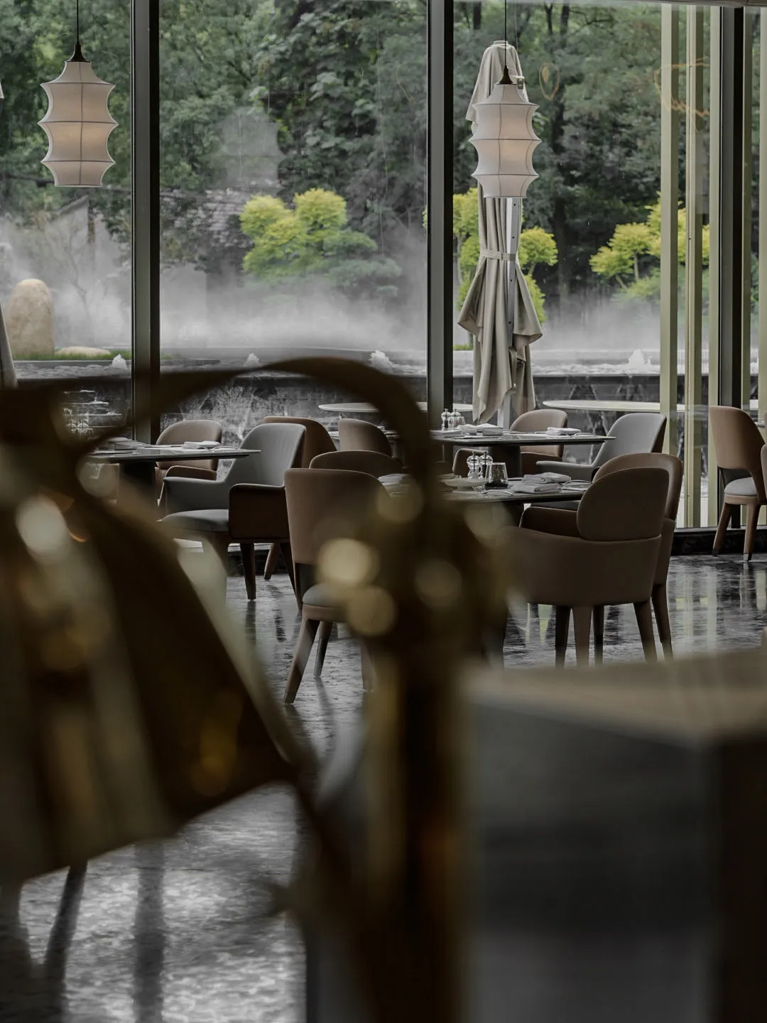 A modern restaurant interior with tables, chairs, and decorative elements arranged in a dining setting.