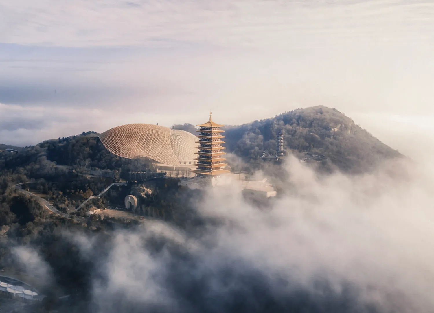 這張圖片呈現一座被雲霧環繞的現代建築結構。