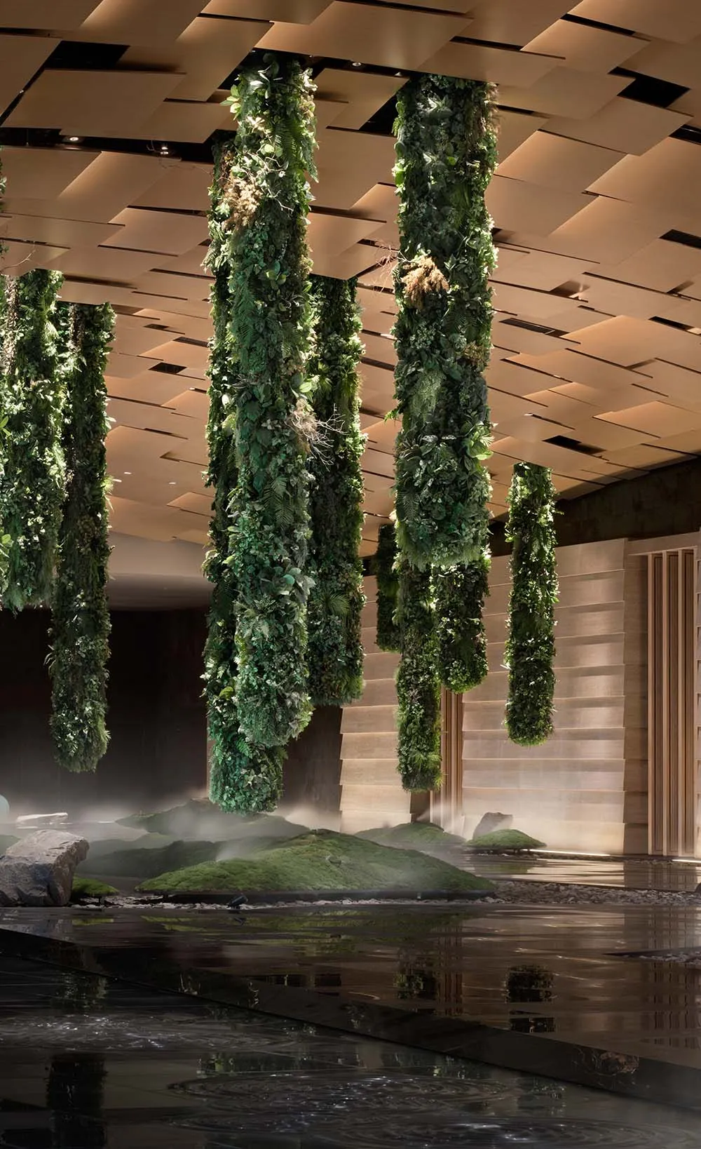 An indoor garden featuring vertical columns covered in lush greenery and moss.
