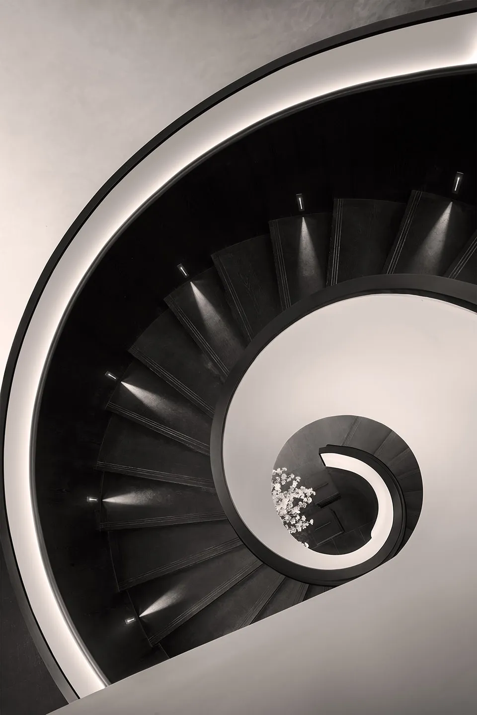 Modern, spiraling staircase with black metal steps and white walls.