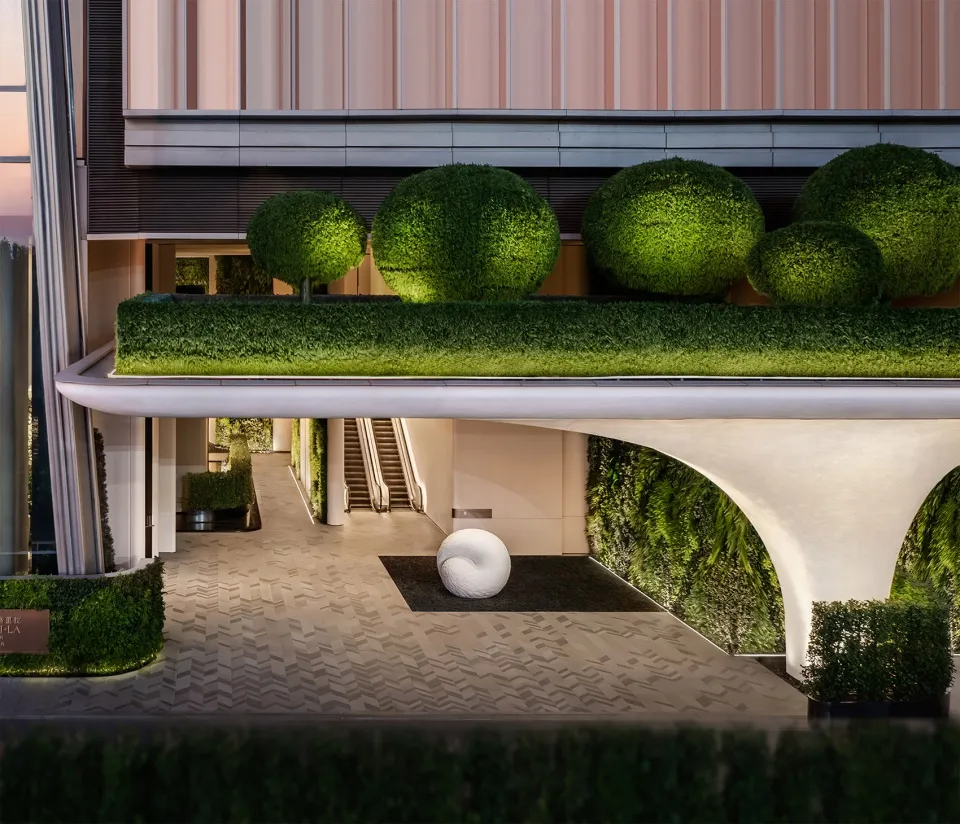 A sleek, minimalist hotel lobby designed with concrete and greenery.