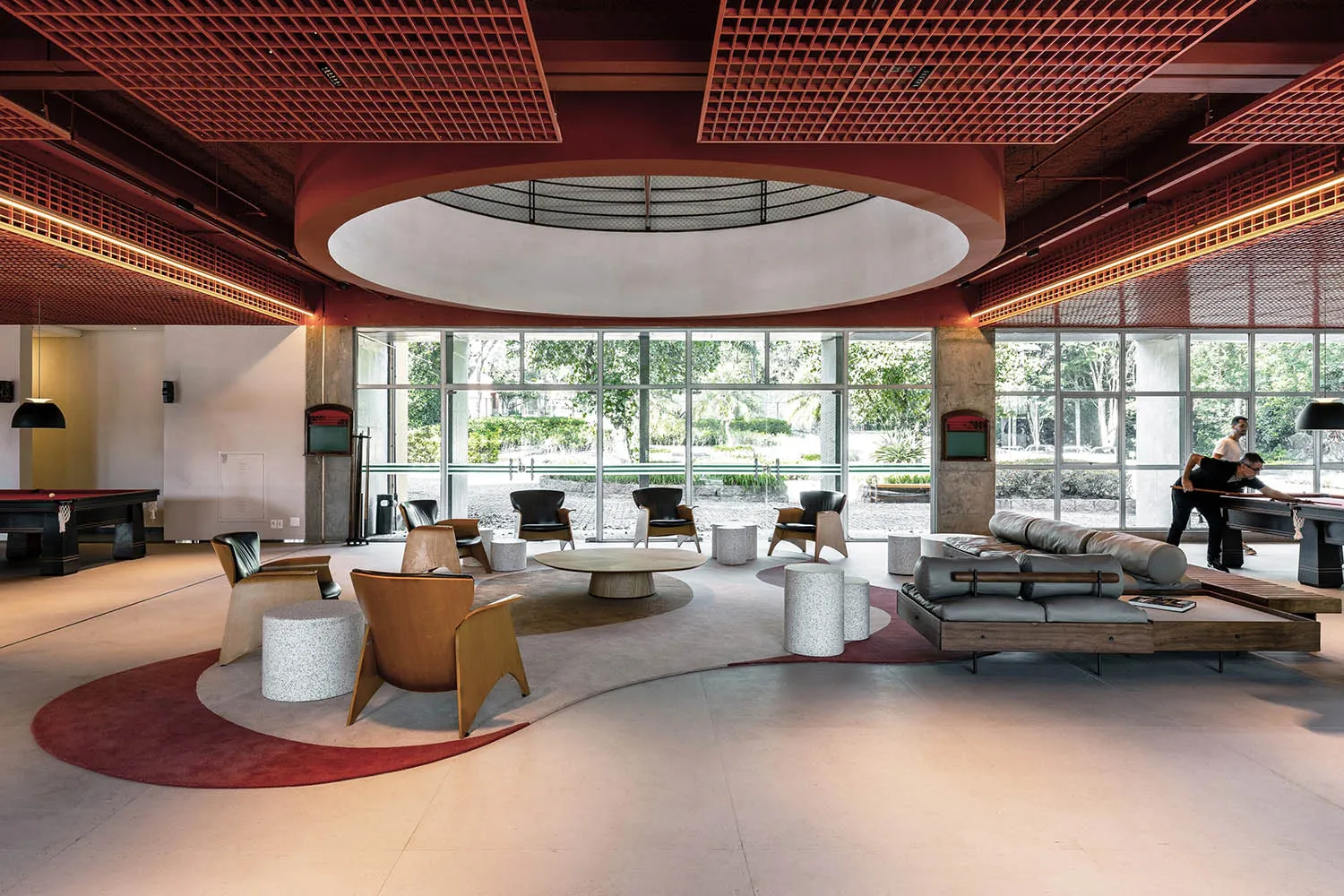 A modern lobby with concrete flooring, wooden furniture, and large windows