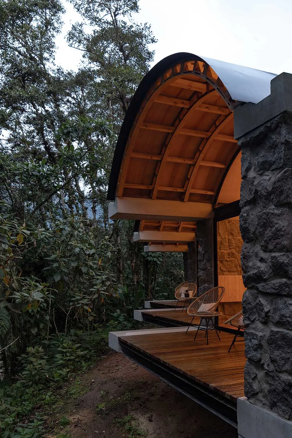 Modern outdoor living space featuring wooden construction and stone columns.