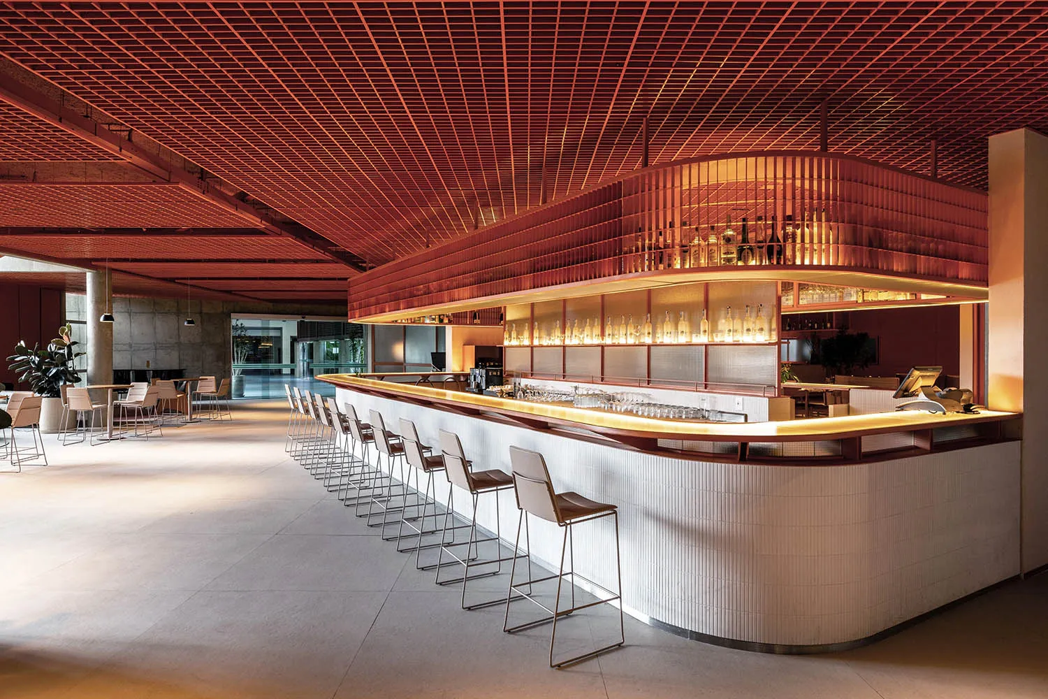 A modern restaurant bar with metallic and wooden features, showcasing contemporary design elements.