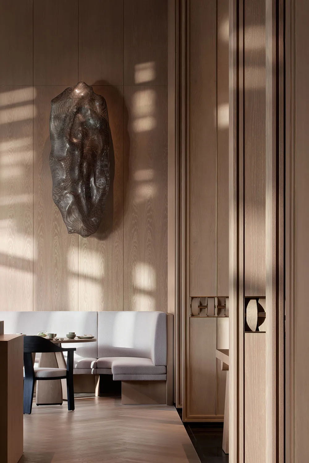Modern restaurant interior with wooden walls and bench seating.