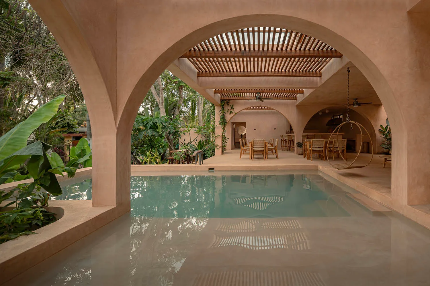 A modern residential interior featuring a terracotta pool house with a sleek, open-plan design.