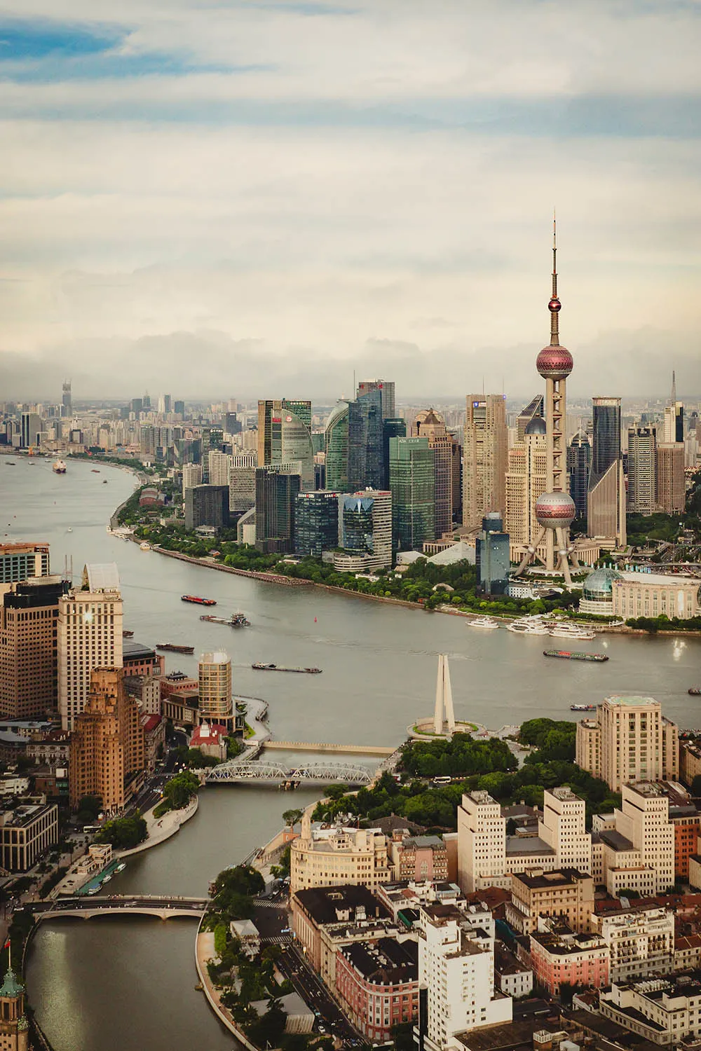 Aerial view of Shanghai skyline and river with boats.