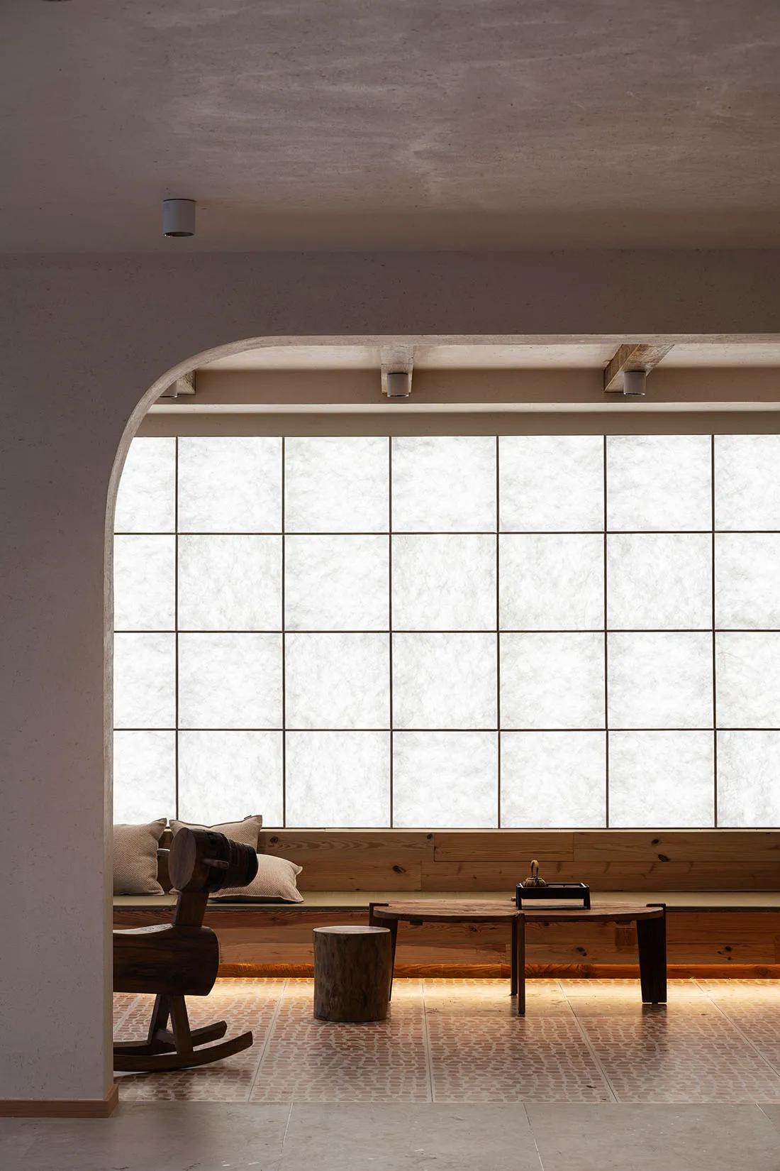 A modern living room with wooden furniture and a large window.