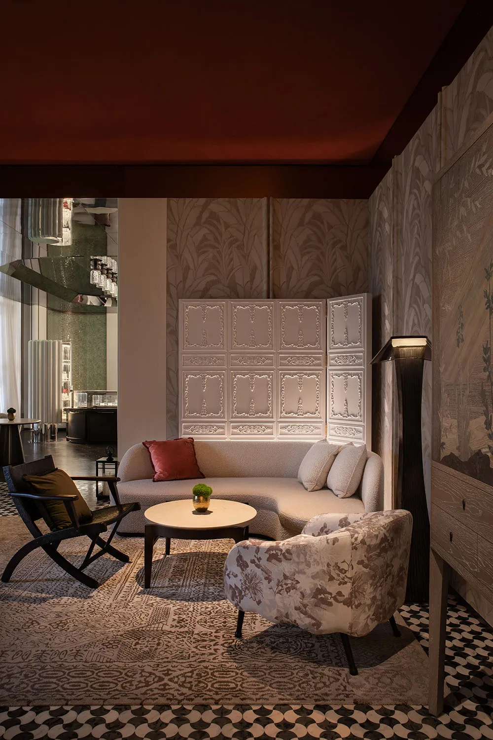 A modern living room with a white sofa, round coffee table, and patterned rug.