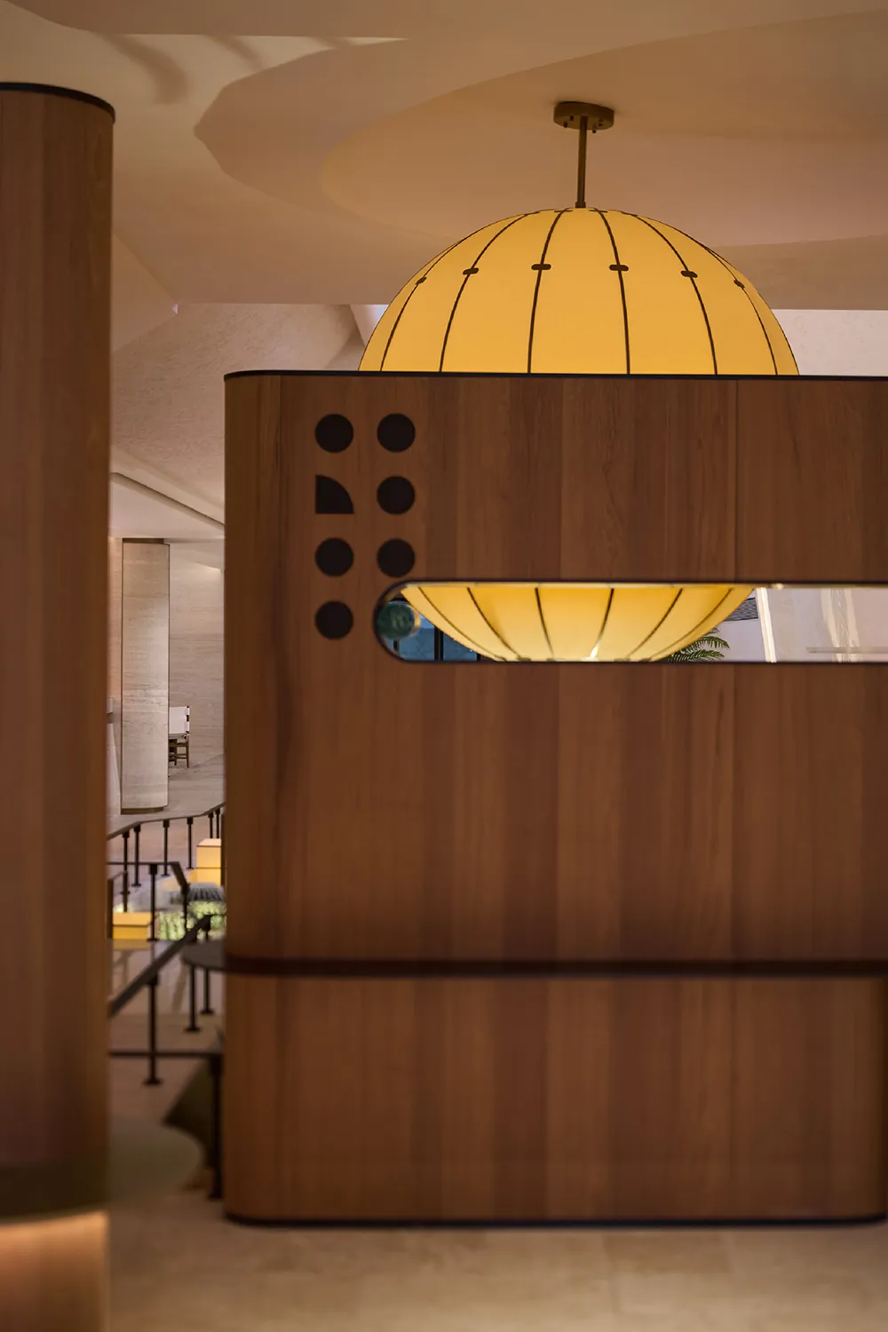 A modern restaurant bar with a wooden counter featuring integrated circular yellow lights.