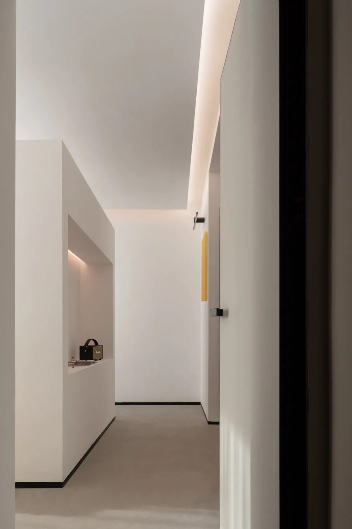 A minimalist white interior with clean lines and a modern design aesthetic, featuring a hallway with a sleek white floor and