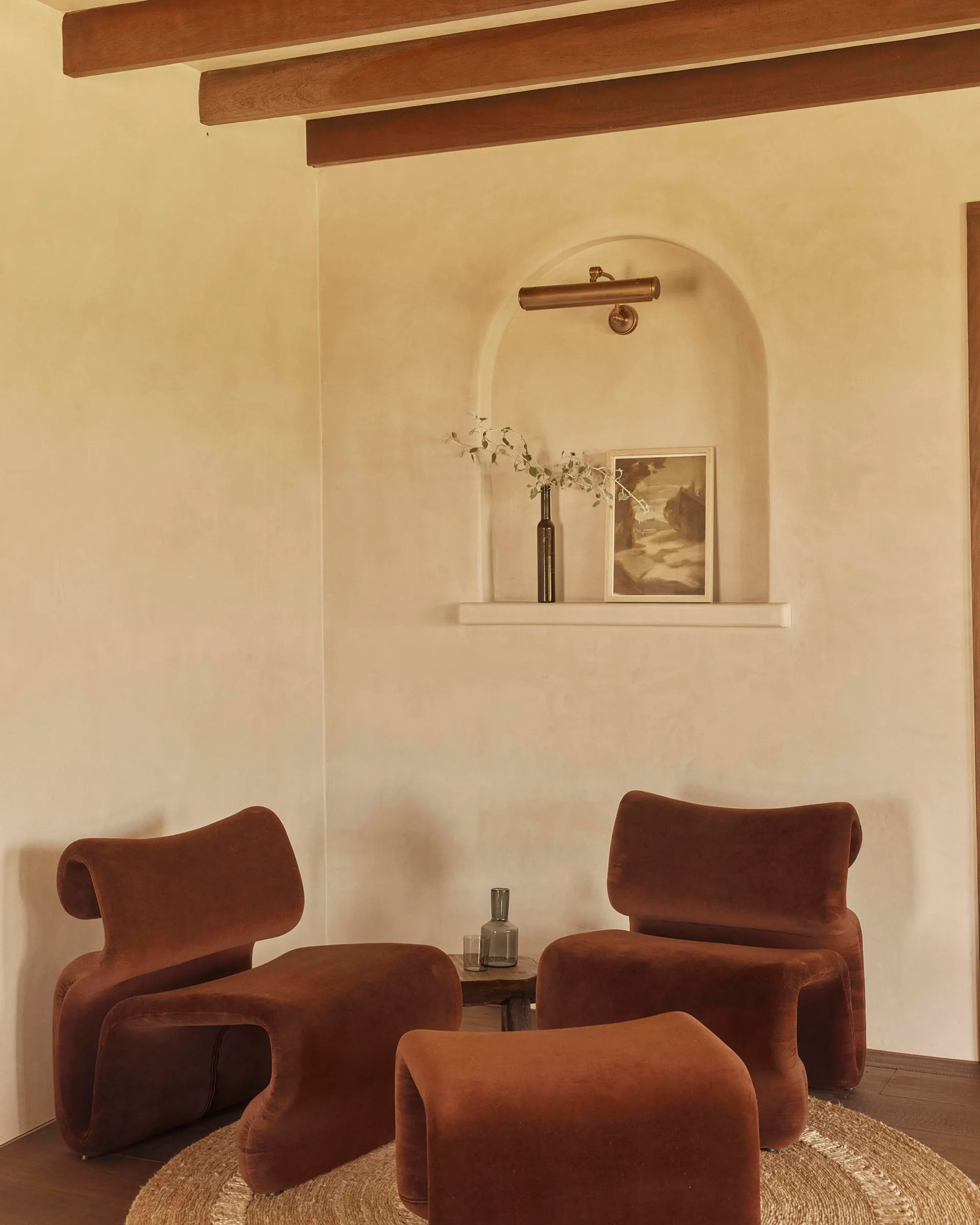 A modern living room featuring comfortable brown velvet couches, a wooden floor, and a warm, inviting ambiance.