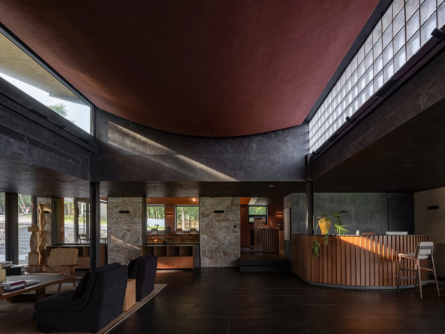 A modern hotel reception area with concrete walls and high ceilings.