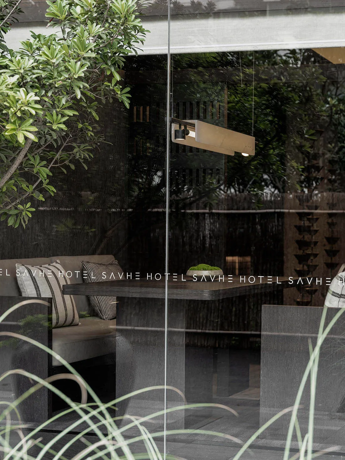 Modern industrial restaurant interior with glass walls and metallic elements.
