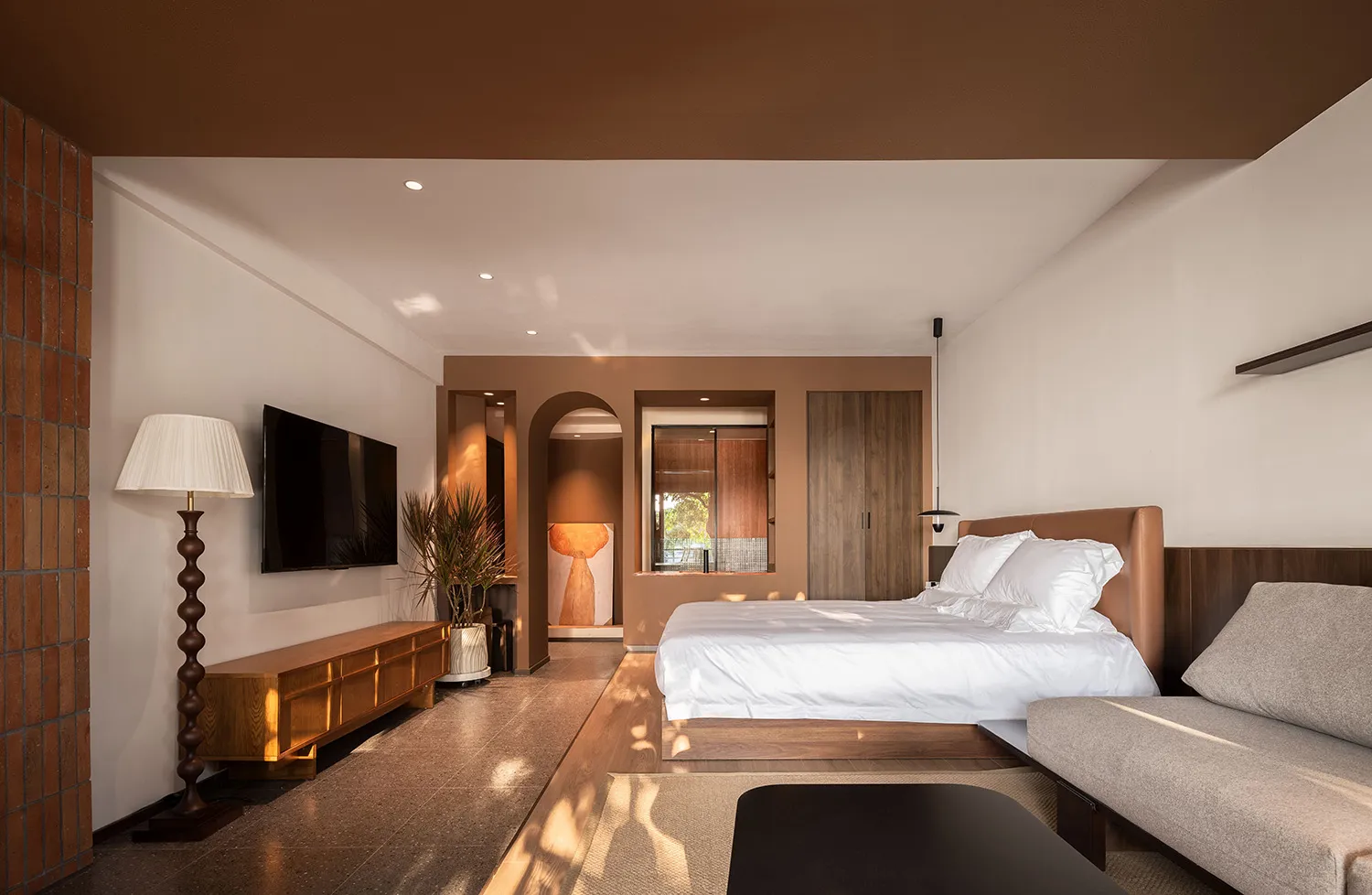 Modern minimalist bedroom featuring wood accents, concrete floor, and a brown leather bed frame.