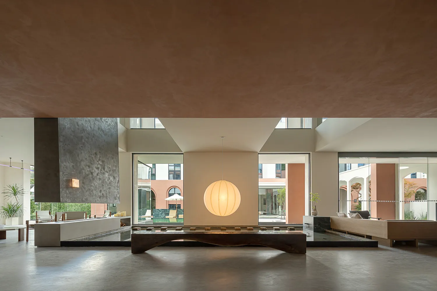 A minimalist living room with concrete flooring and minimalist furniture.